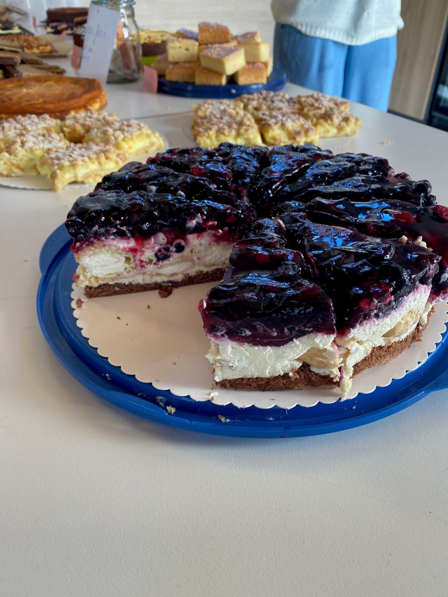 Beerentorte vor einer Auswahl selbstgebackener Kuchen